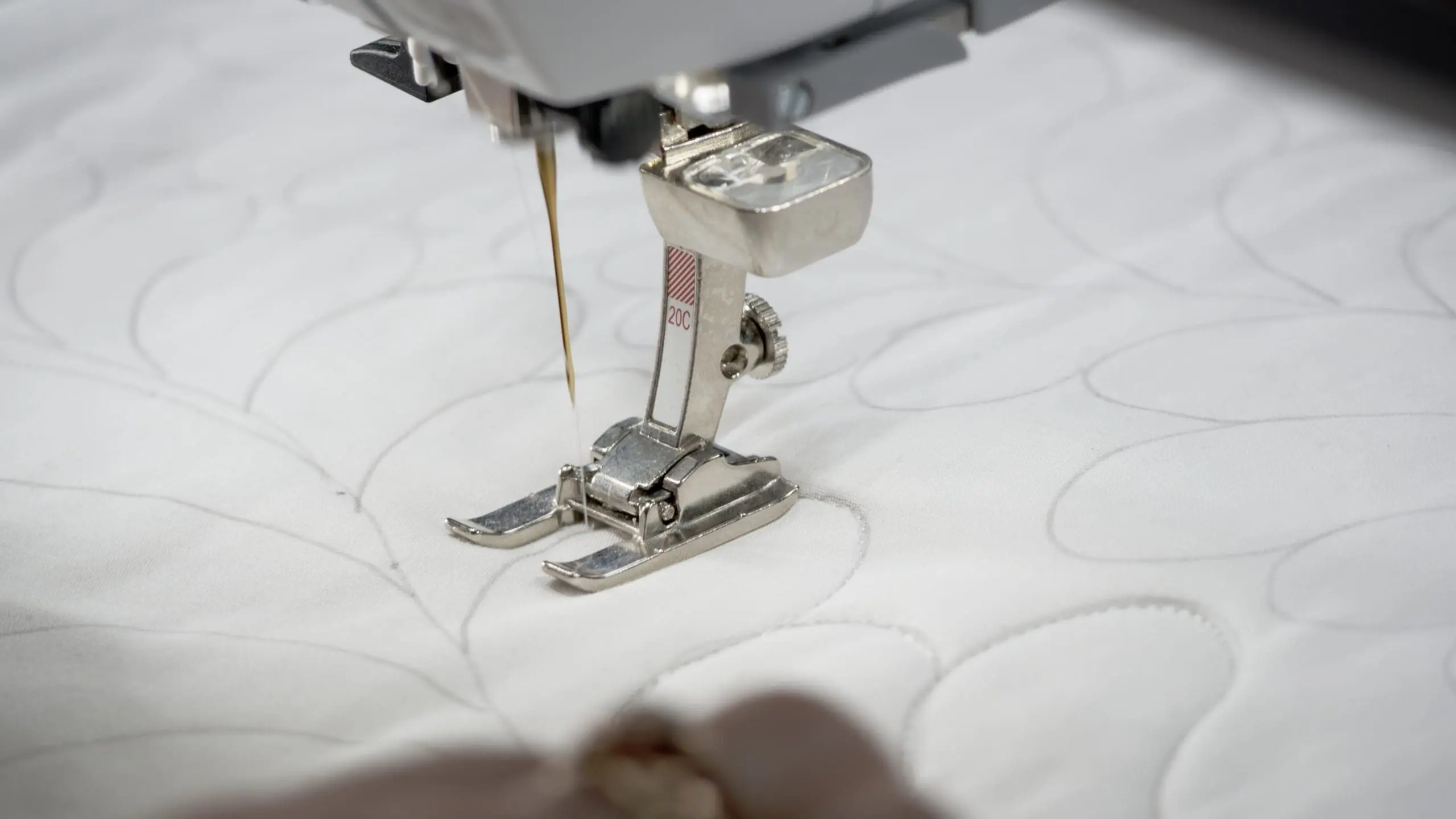 Close-up of quilting being done on a domestic sewing machine using the QISS system